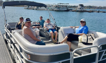 Family siting on keowee marina's pontoon rental on lake keowee