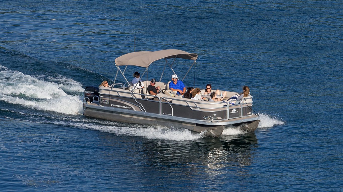Pontoon boat cruising on a calm lake with passengers enjoying a leisure boating experience | Keowee Marina