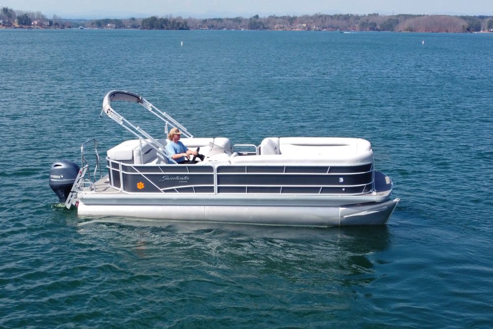 Pontoon boat rental cruising on Lake Keowee with scenic shoreline views | Keowee Marina