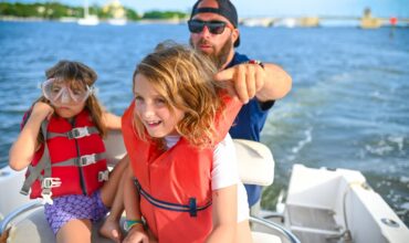 Family enjoying fun and safe boat rental at Lake Keowee with kids wearing life jackets at Keowee Marina.