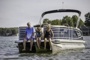 Family enjoying a pontoon boat rental on Lake Keowee with feet in the water | Keowee Marina