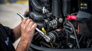 Marine technician performing boat engine maintenance for spring readiness - Keowee Marina